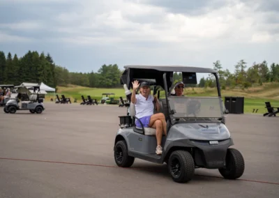 Women waving from a golf cart image